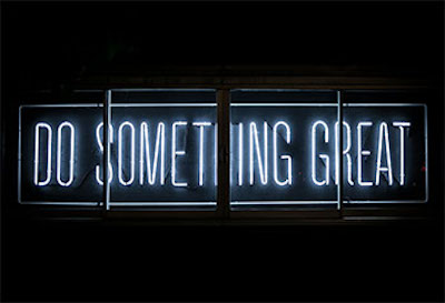 A neon sign displaying the words Do Something Great
